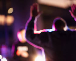 A person raises their hands during a nighttime police encounter, with blurred emergency lights in the background — the unexpected arrest scenario a Springfield warrant lawyer like W. Scott Hanken helps clients avoid.